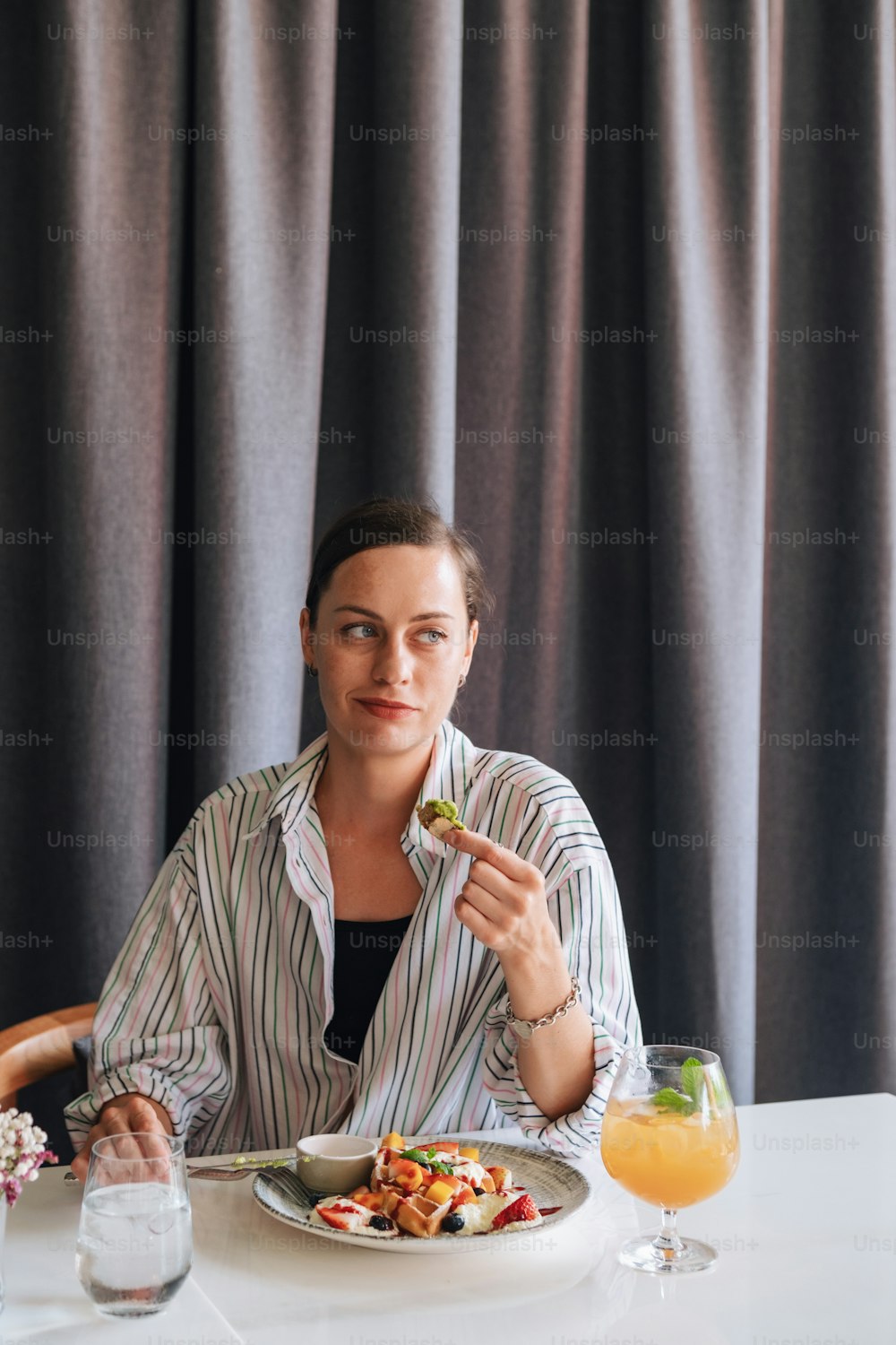 a woman sitting at a table with a plate of food