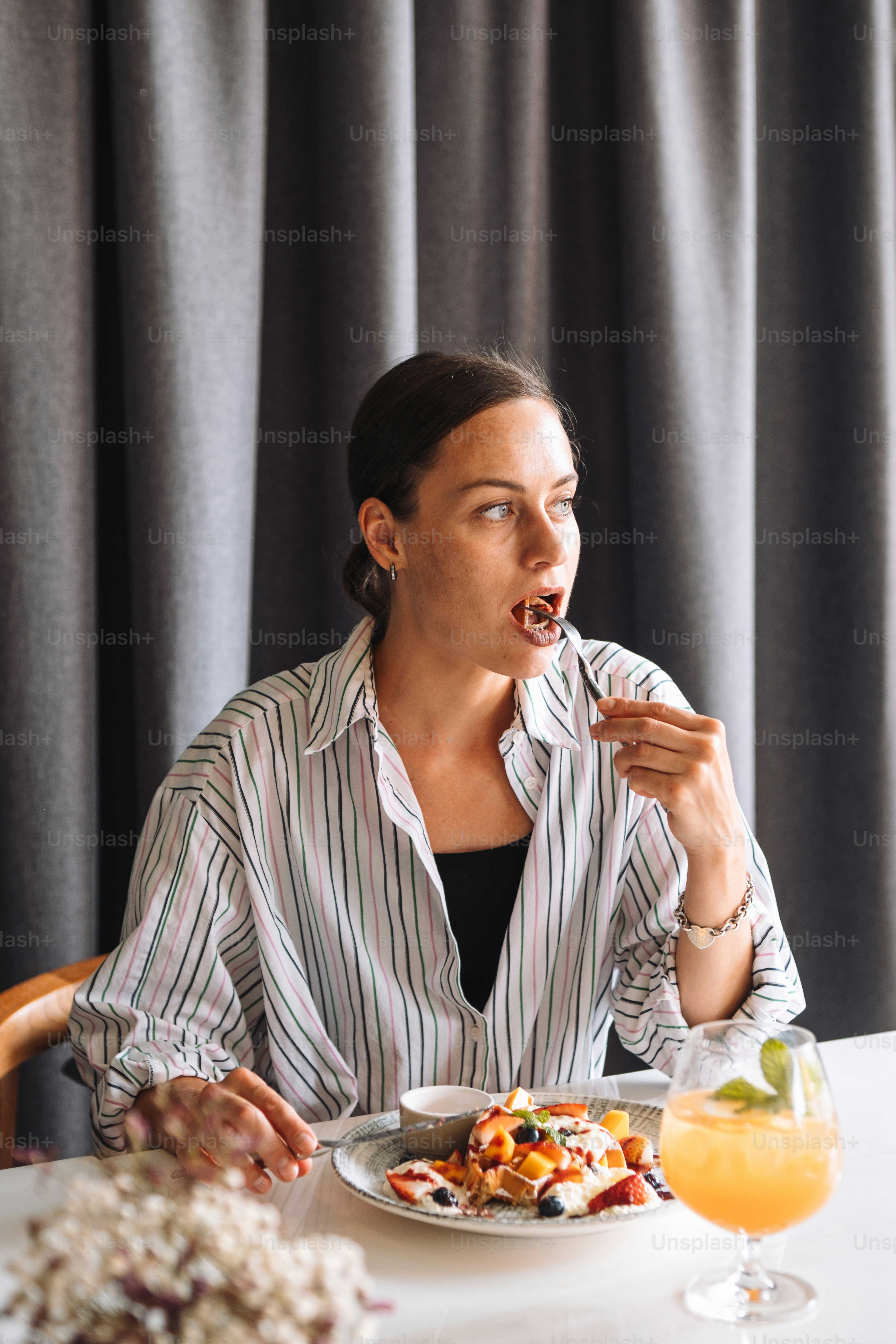 uma mulher sentada em uma mesa com um prato de comida