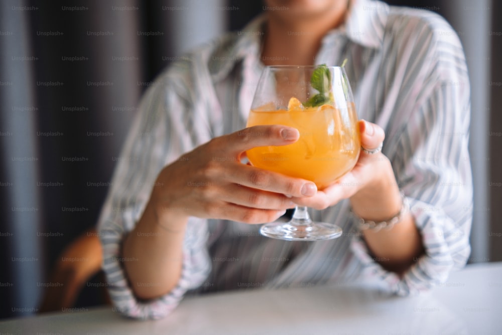 オレンジジュースのグラスを持つ女性