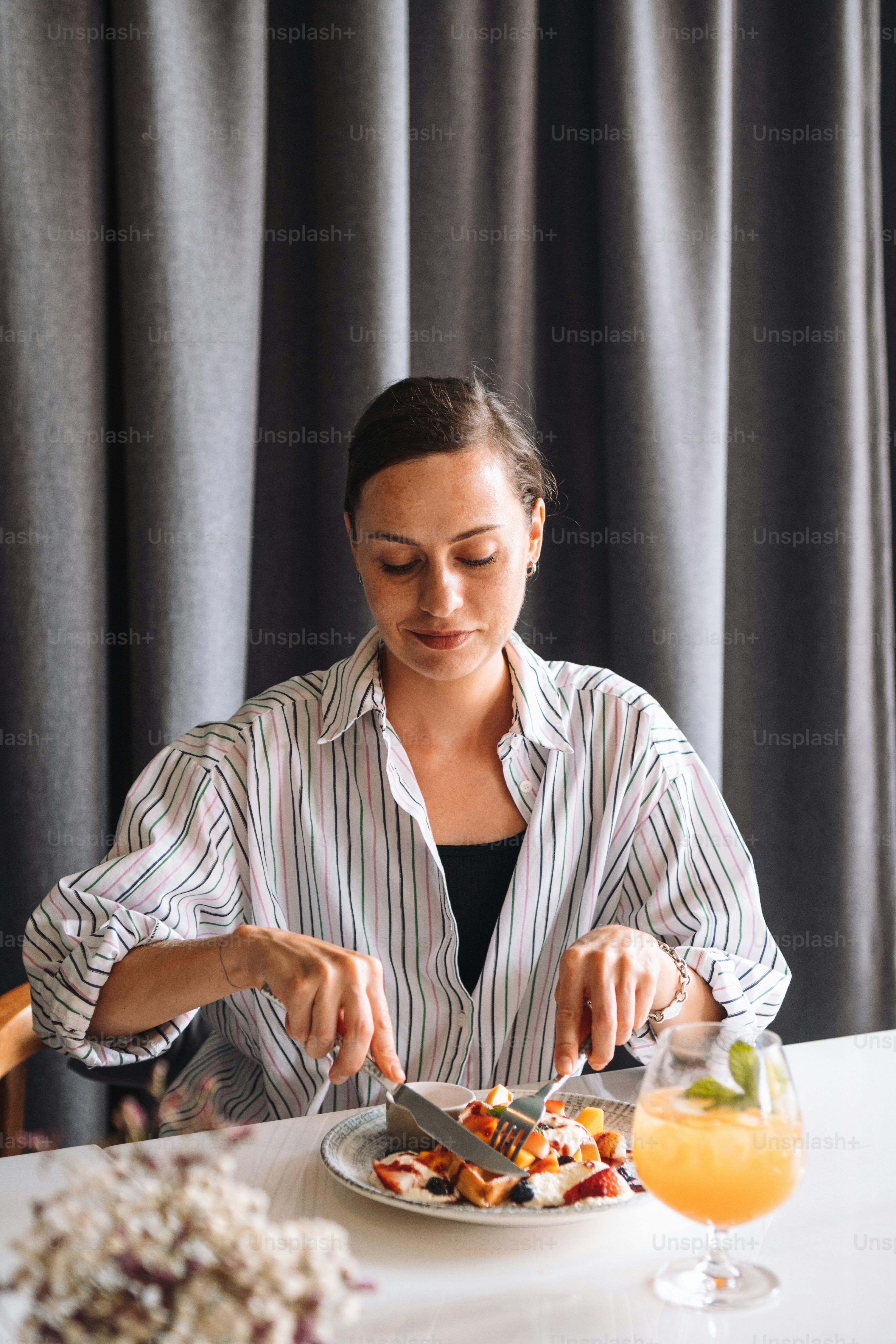 a woman sitting at a table with a plate of food