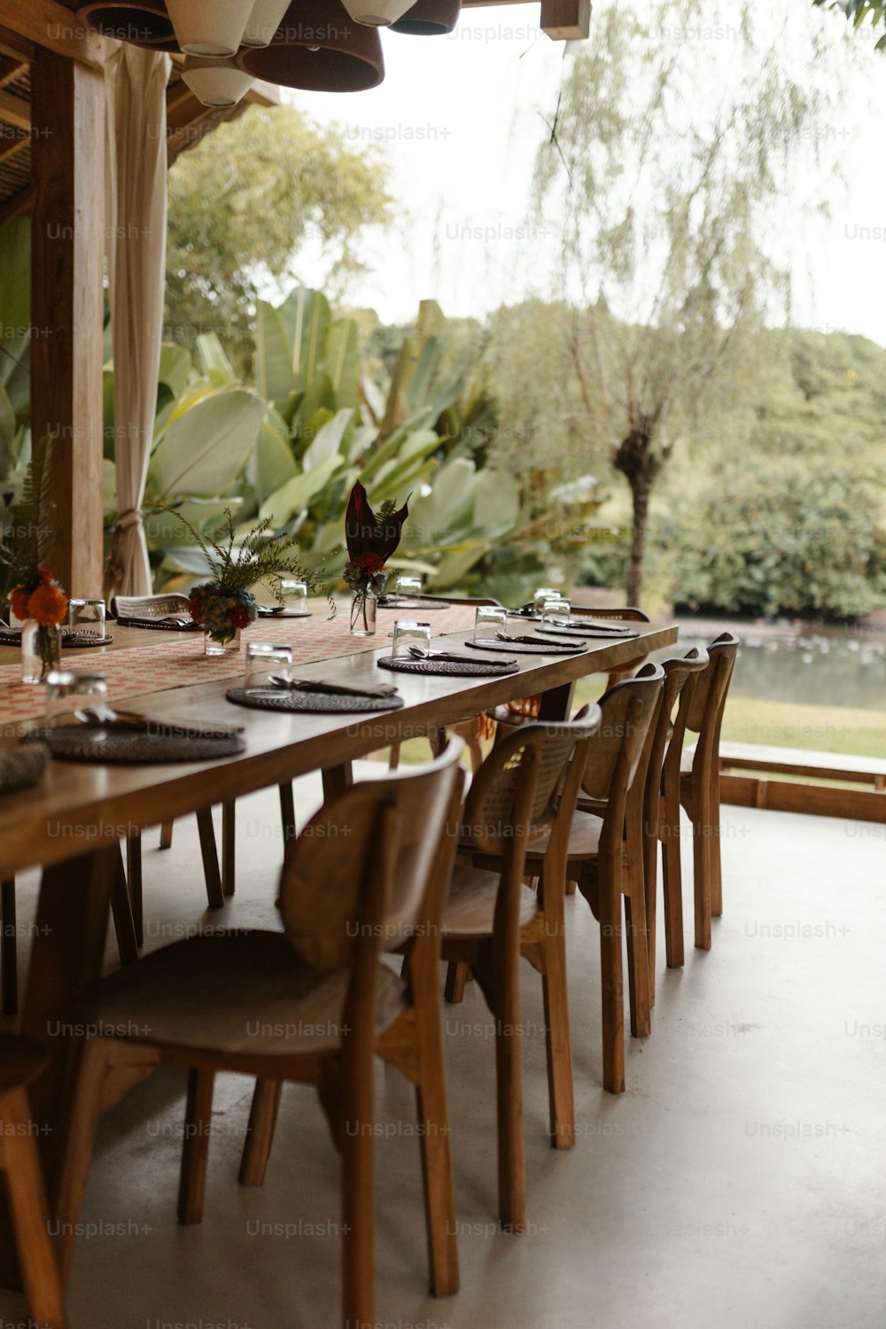 a long wooden table set with place settings