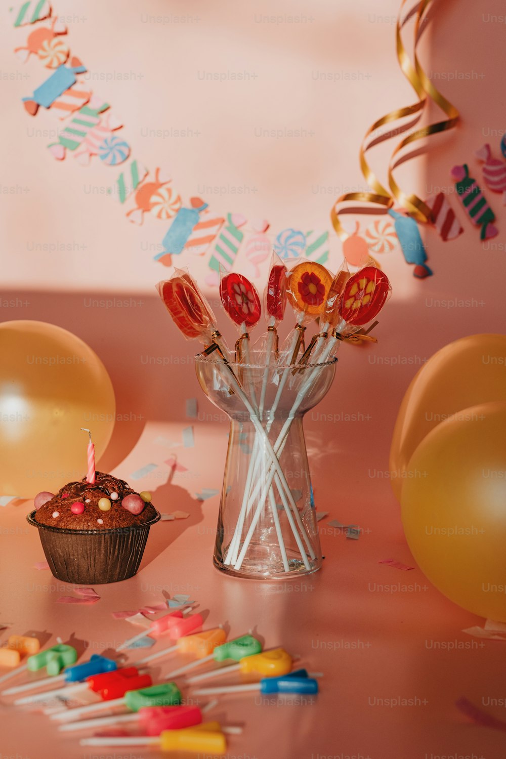 um cupcake em uma mesa com balões e confetes