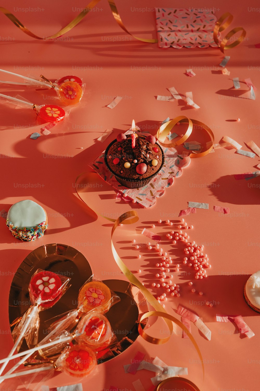 uma mesa coberta com um bolo e muitos confetes