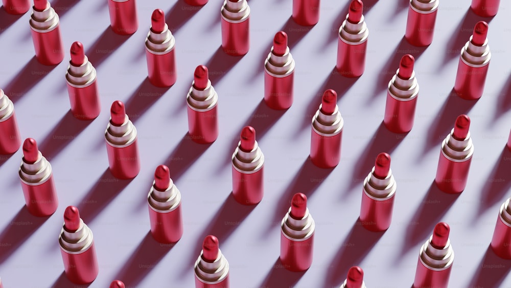 Un grupo de lápices labiales rojos y blancos sobre una superficie púrpura
