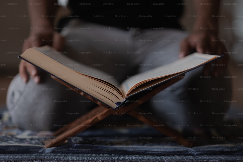 Eine Person, die auf einem Stuhl sitzt und ein Buch liest
