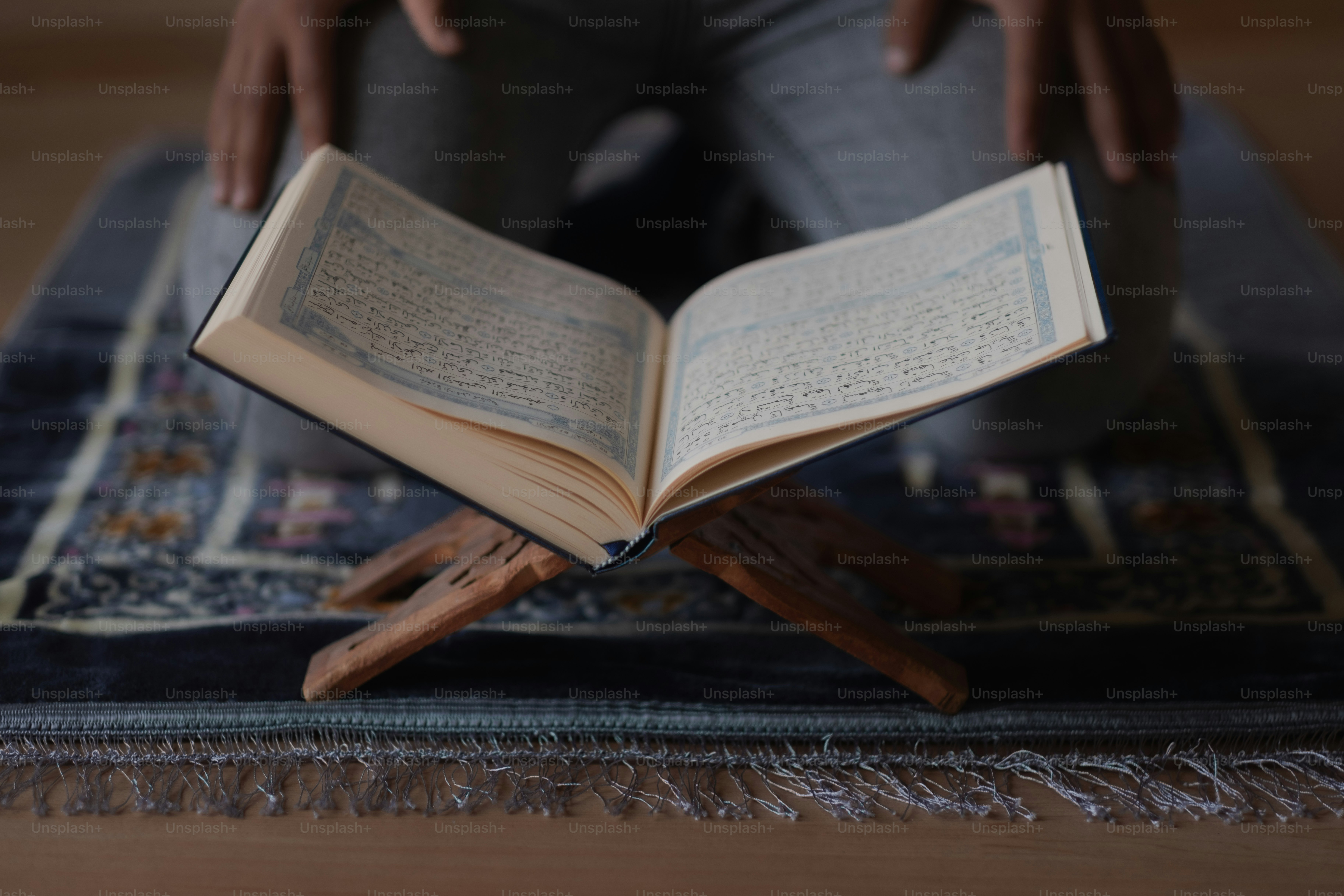 a person sitting on a rug reading a book