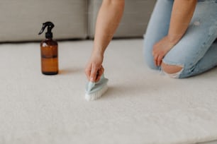 a person cleaning a carpet with a brush