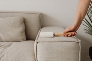 a person holding a rolling pin on top of a couch