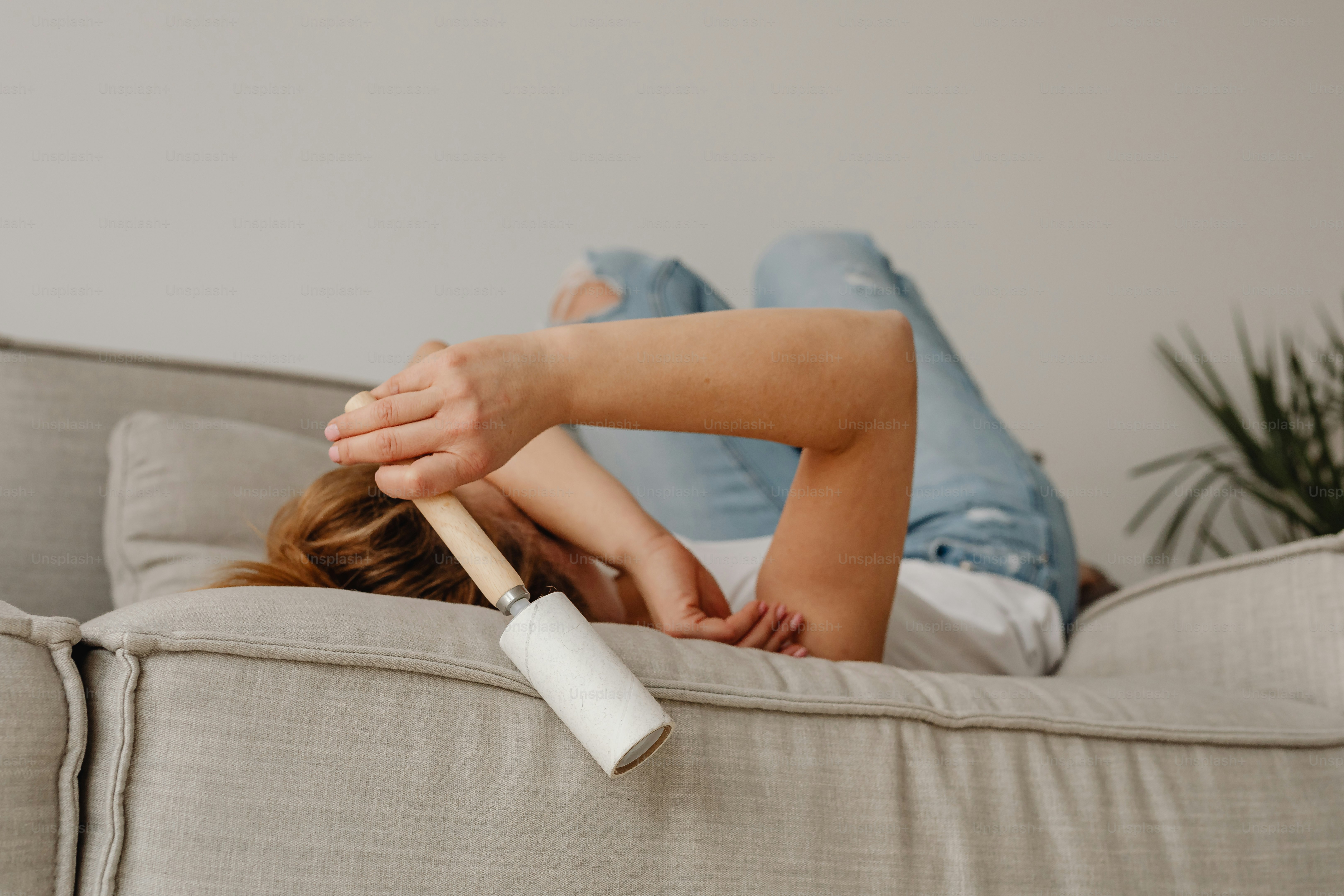 a woman laying on top of a couch holding a bat