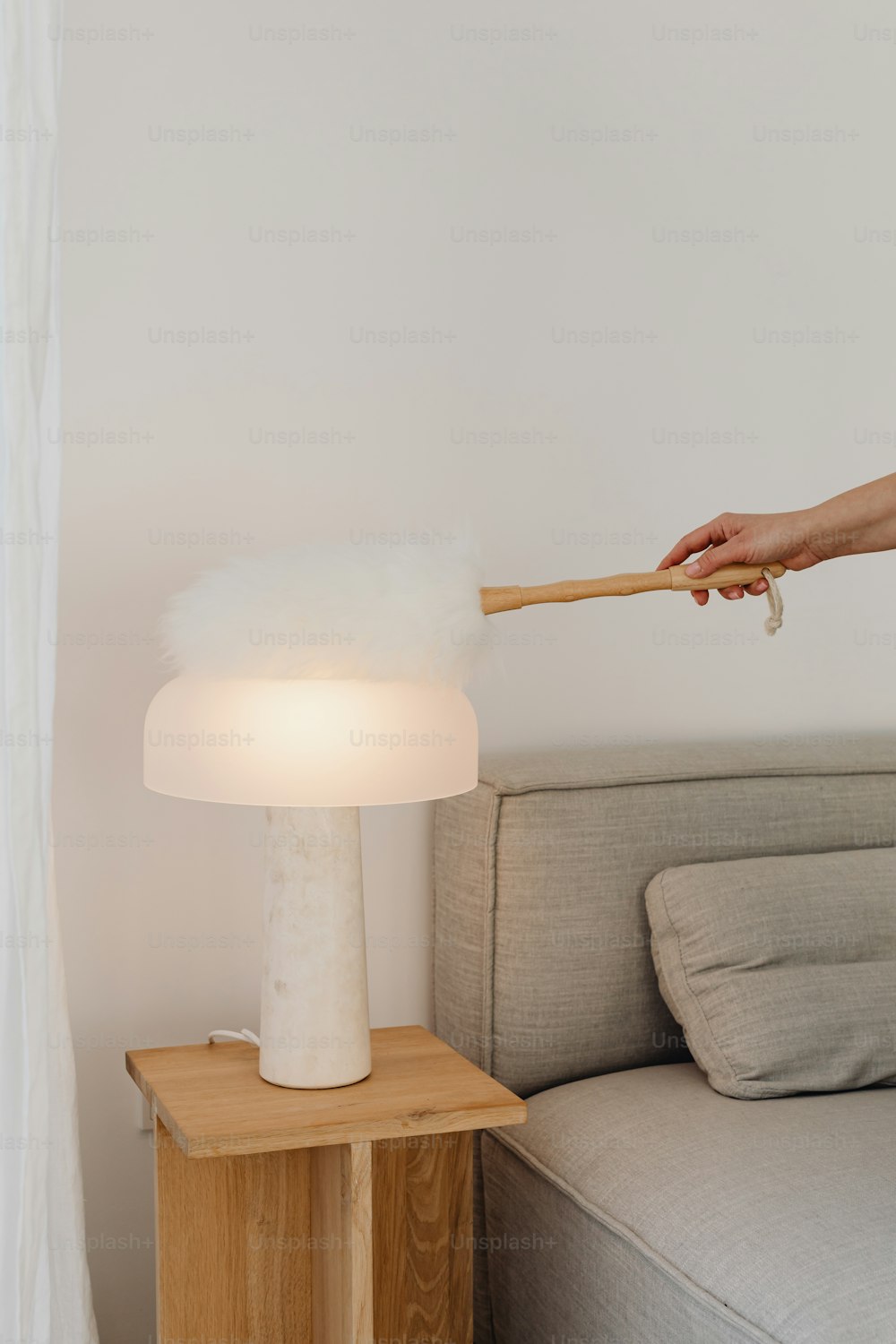 a person is holding a stick over a table lamp
