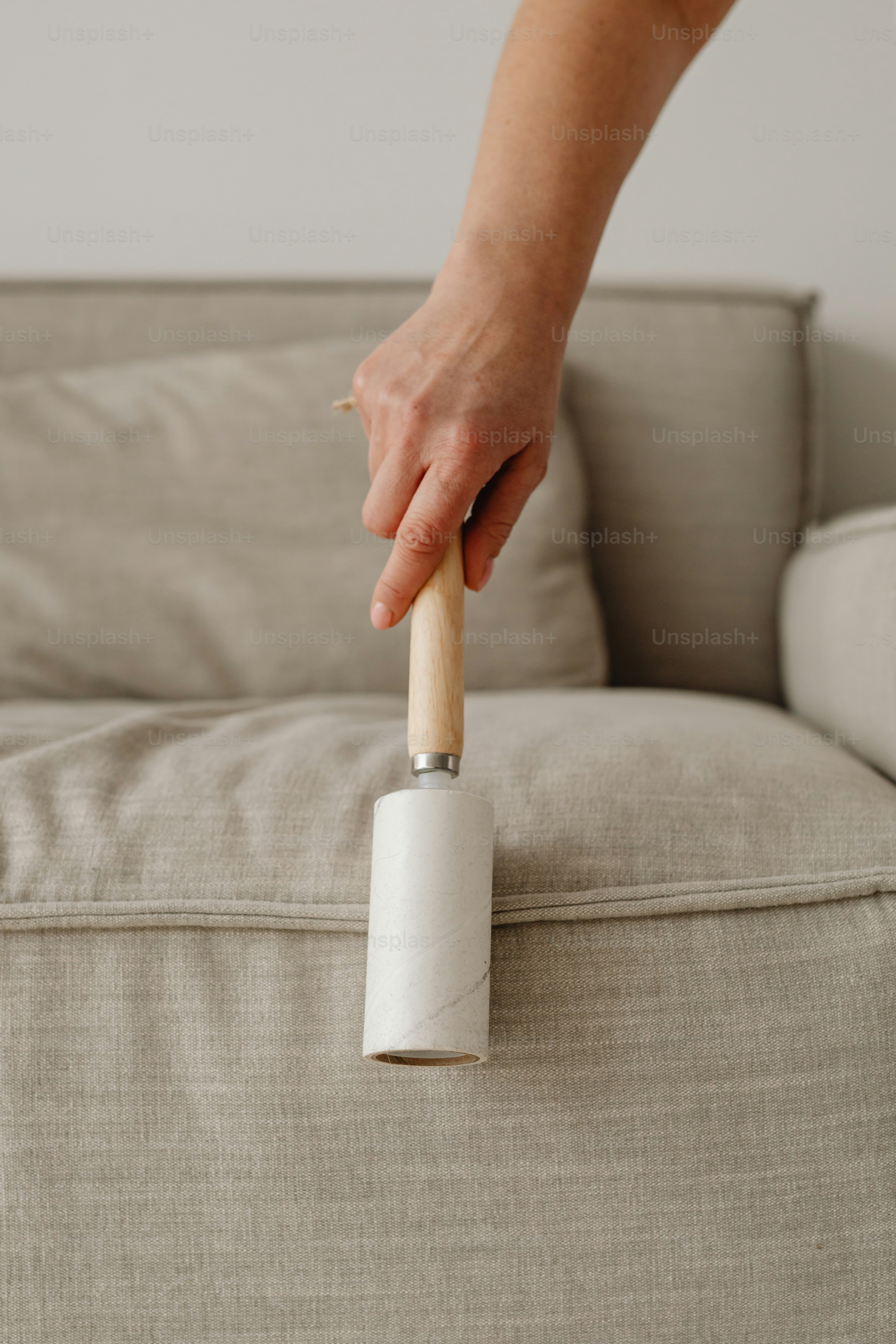 a person holding a roll of toilet paper on a couch