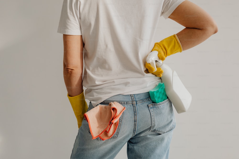 a person wearing yellow gloves and a white t - shirt