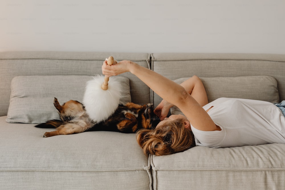 Una persona acostada en un sofá con un perro