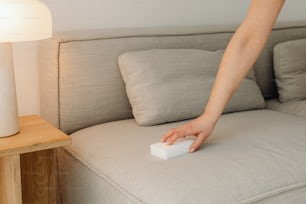 a person is cleaning a couch with a sponge