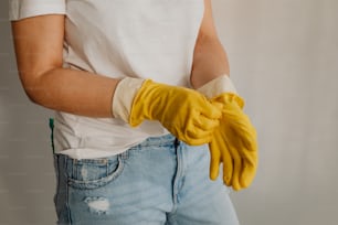 a person wearing a pair of yellow gloves