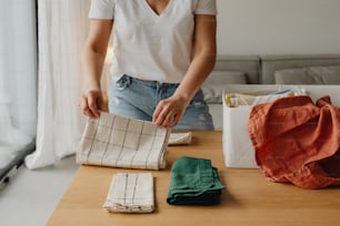 a woman in a white shirt and some cloths on a table