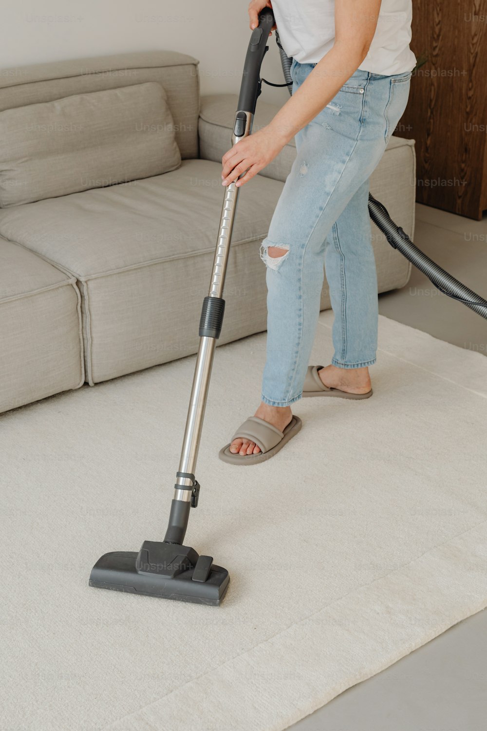 a woman using a vacuum to clean a carpet