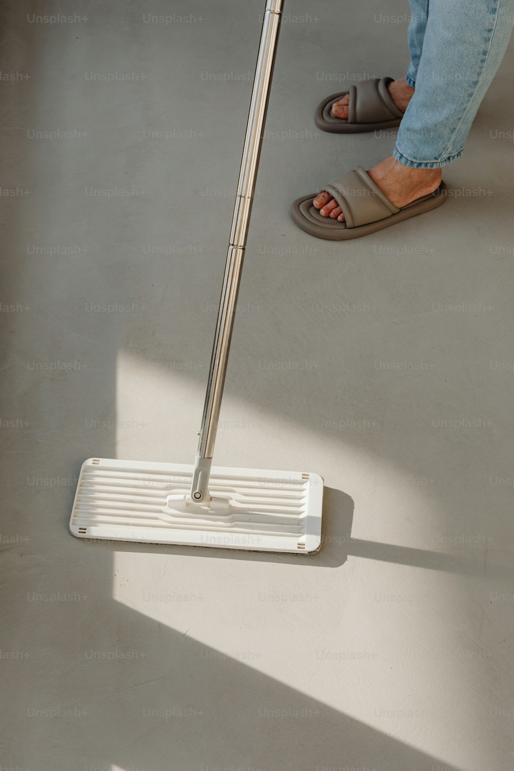 a person standing on a floor with a mop