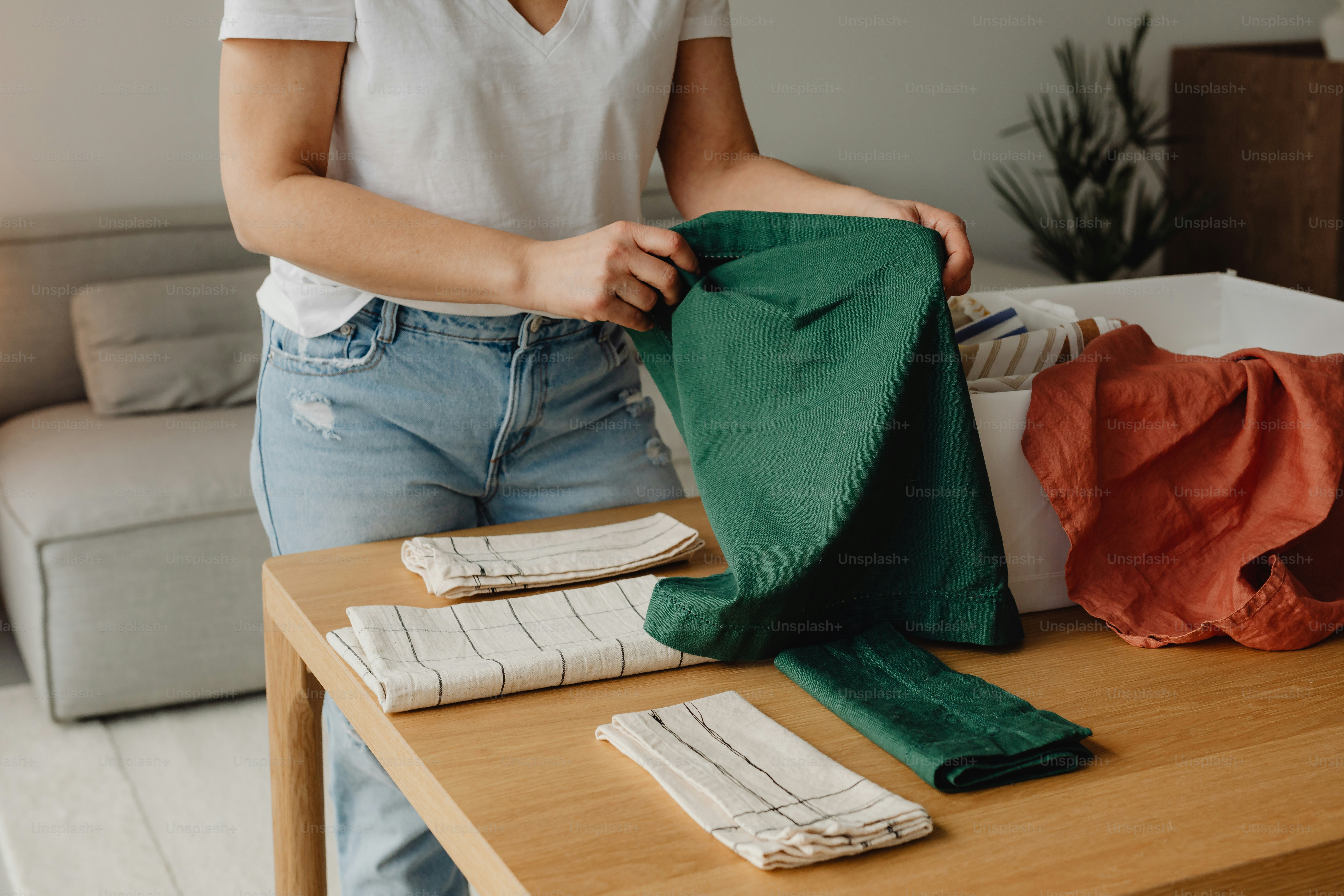 a woman is holding a green bag on a table