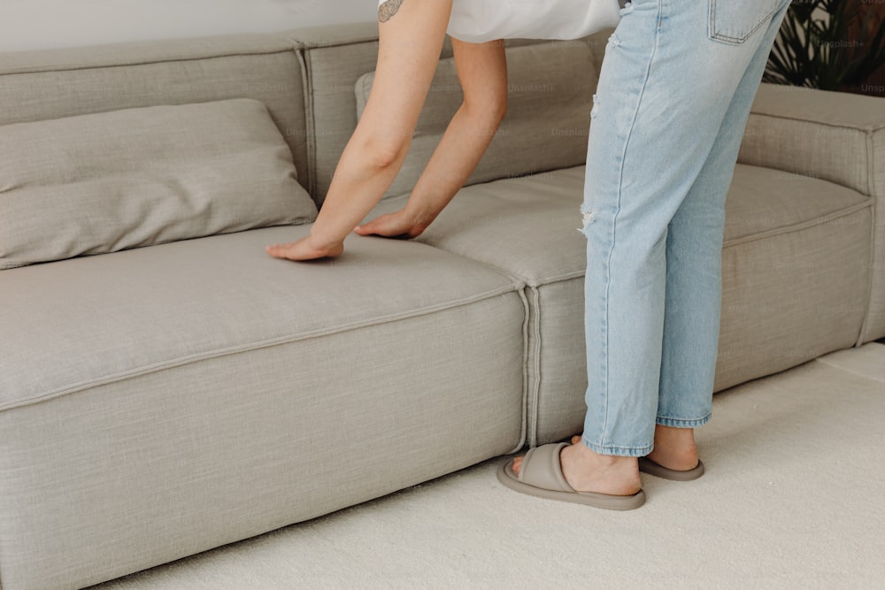 a woman standing on a couch with her foot on the couch