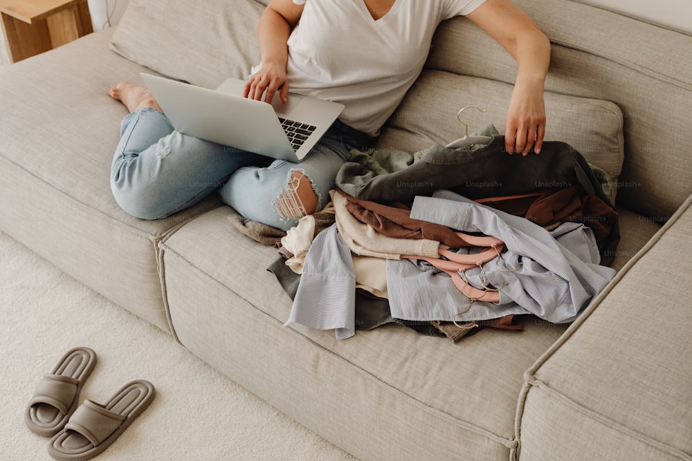 uma mulher sentada em um sofá com um laptop