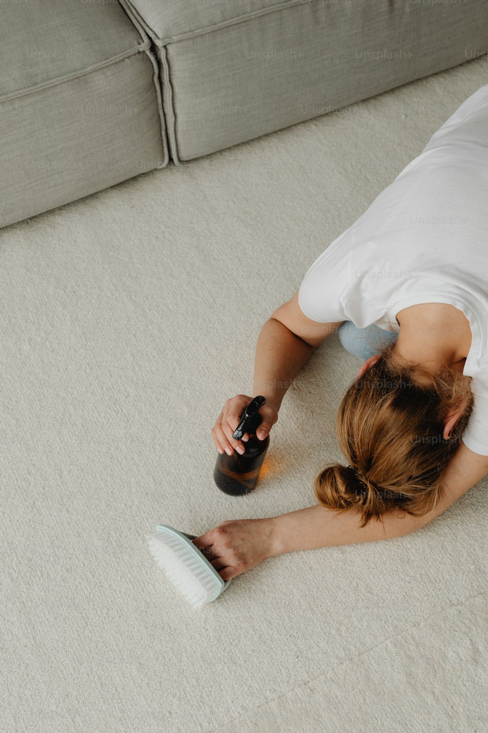 a woman laying on the floor with a bottle of beer