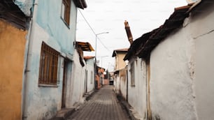 a cobblestone street lined with white buildings