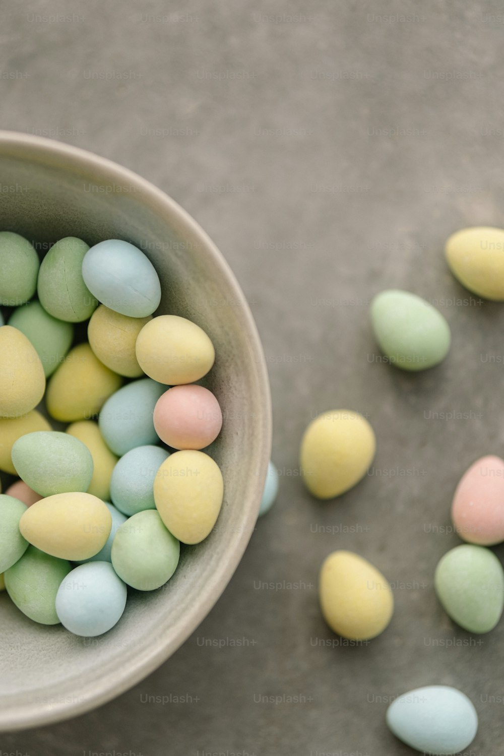 a bowl filled with pastel colored eggs