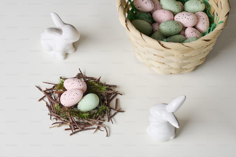 a basket filled with eggs next to a small white bunny