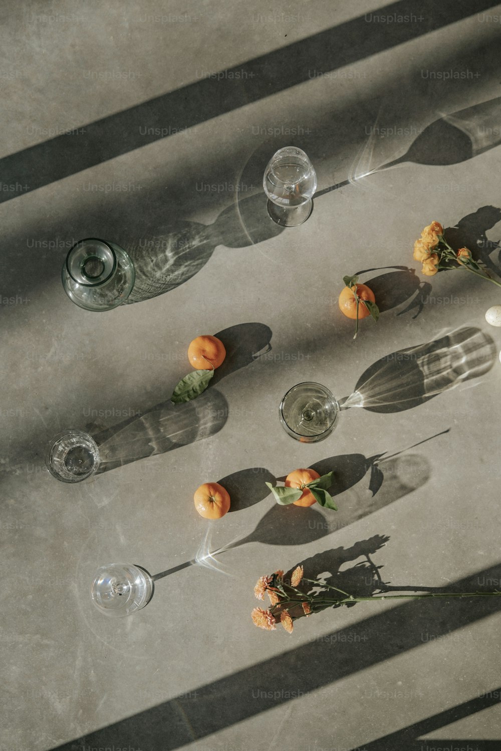 a table with several glasses and flowers on it