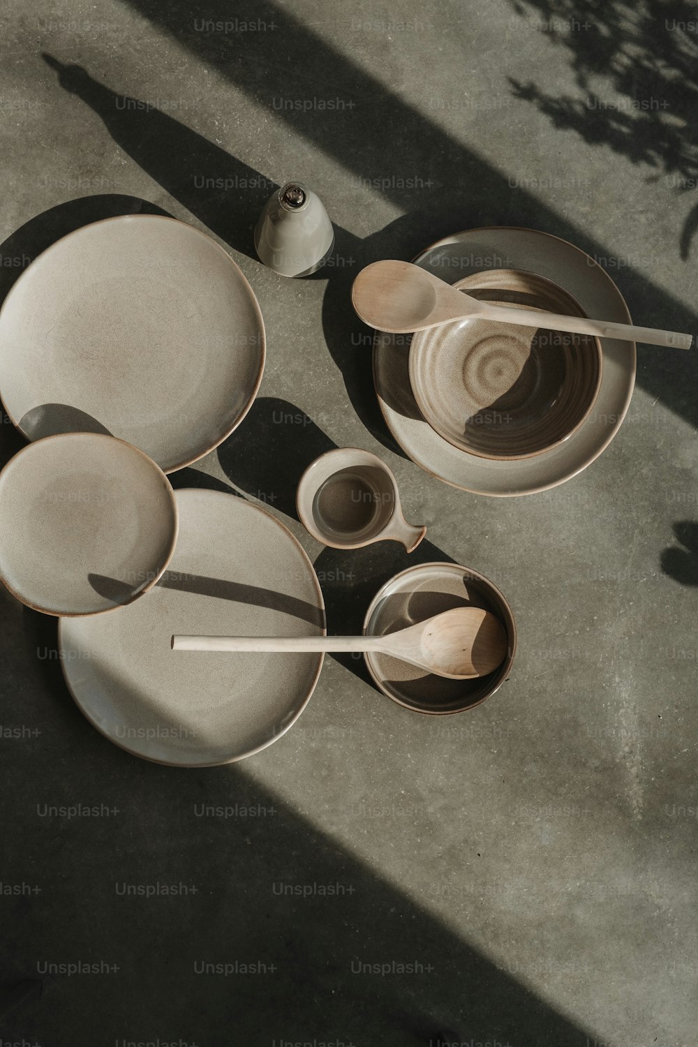 a table topped with white dishes and wooden spoons
