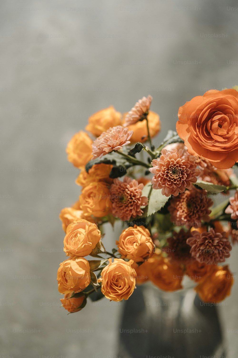 eine Vase gefüllt mit orangefarbenen Blumen auf einem Tisch