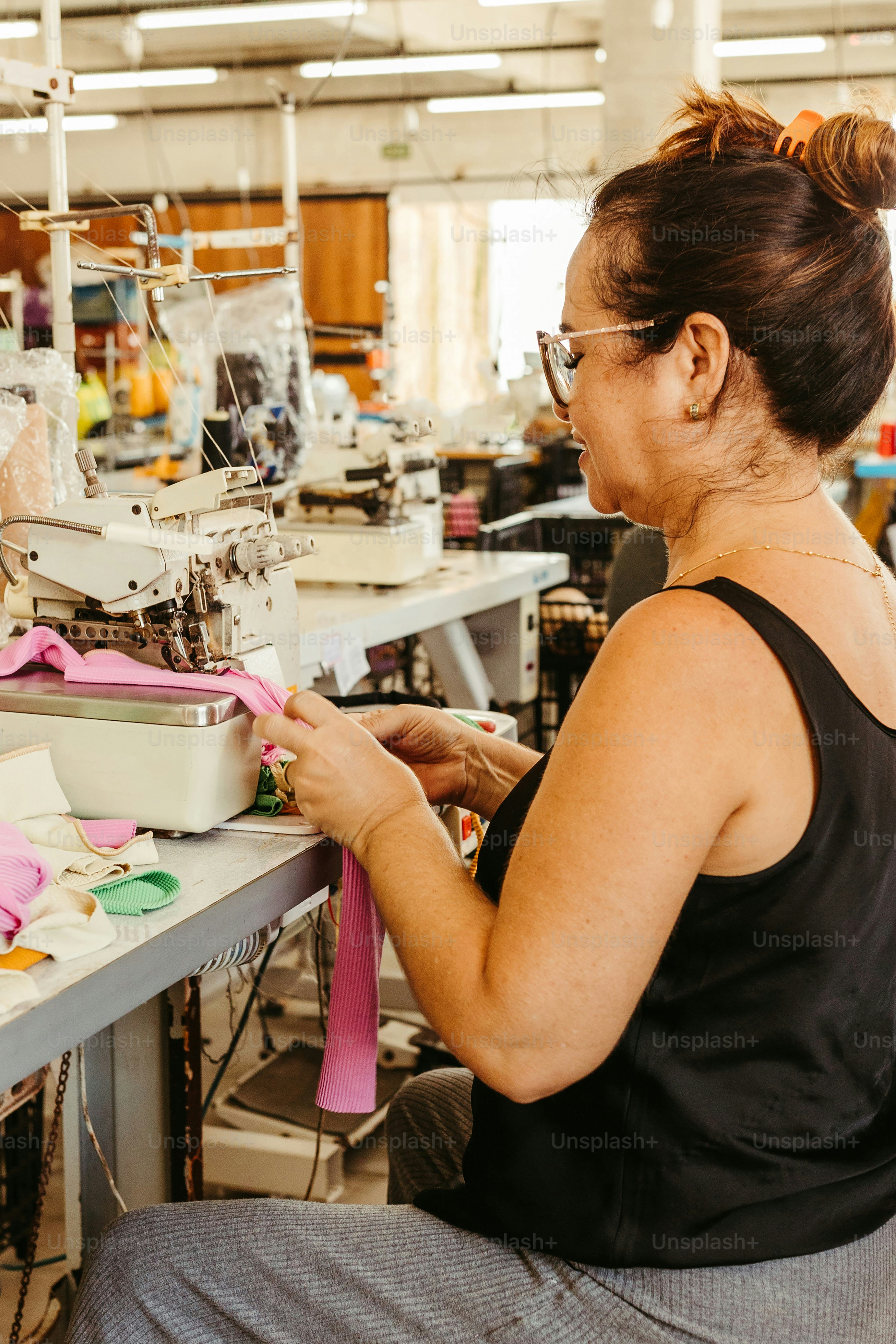 a woman working on a sewing machine in a factory