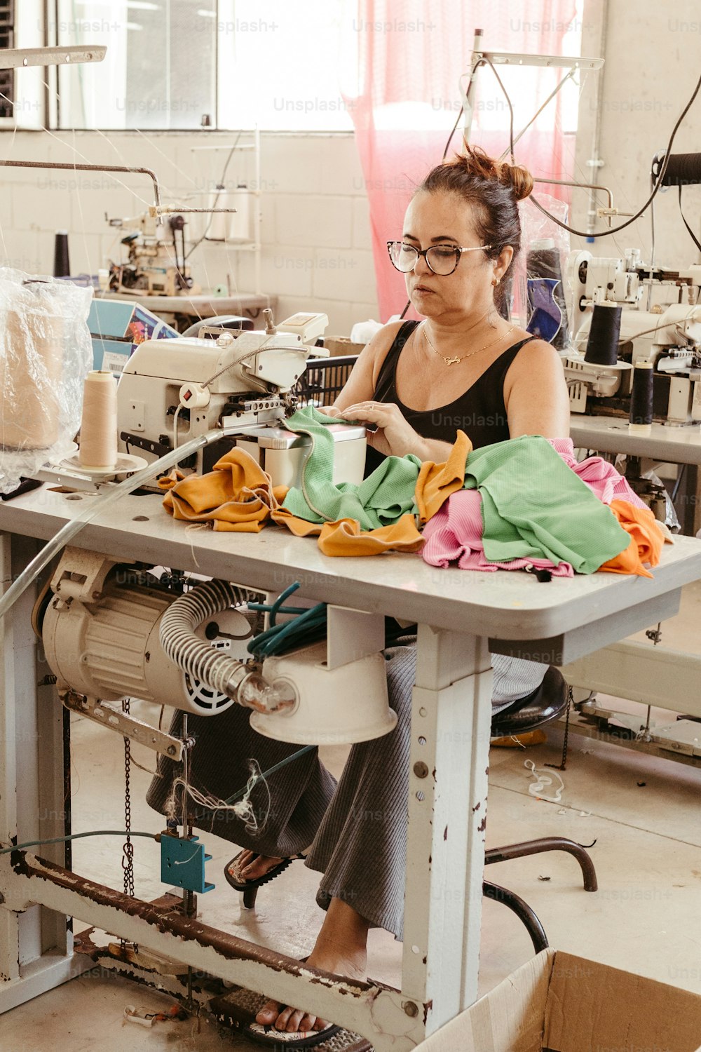 a woman working on a sewing machine in a factory