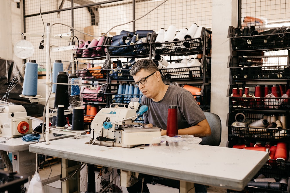 a man working on a sewing machine in a factory