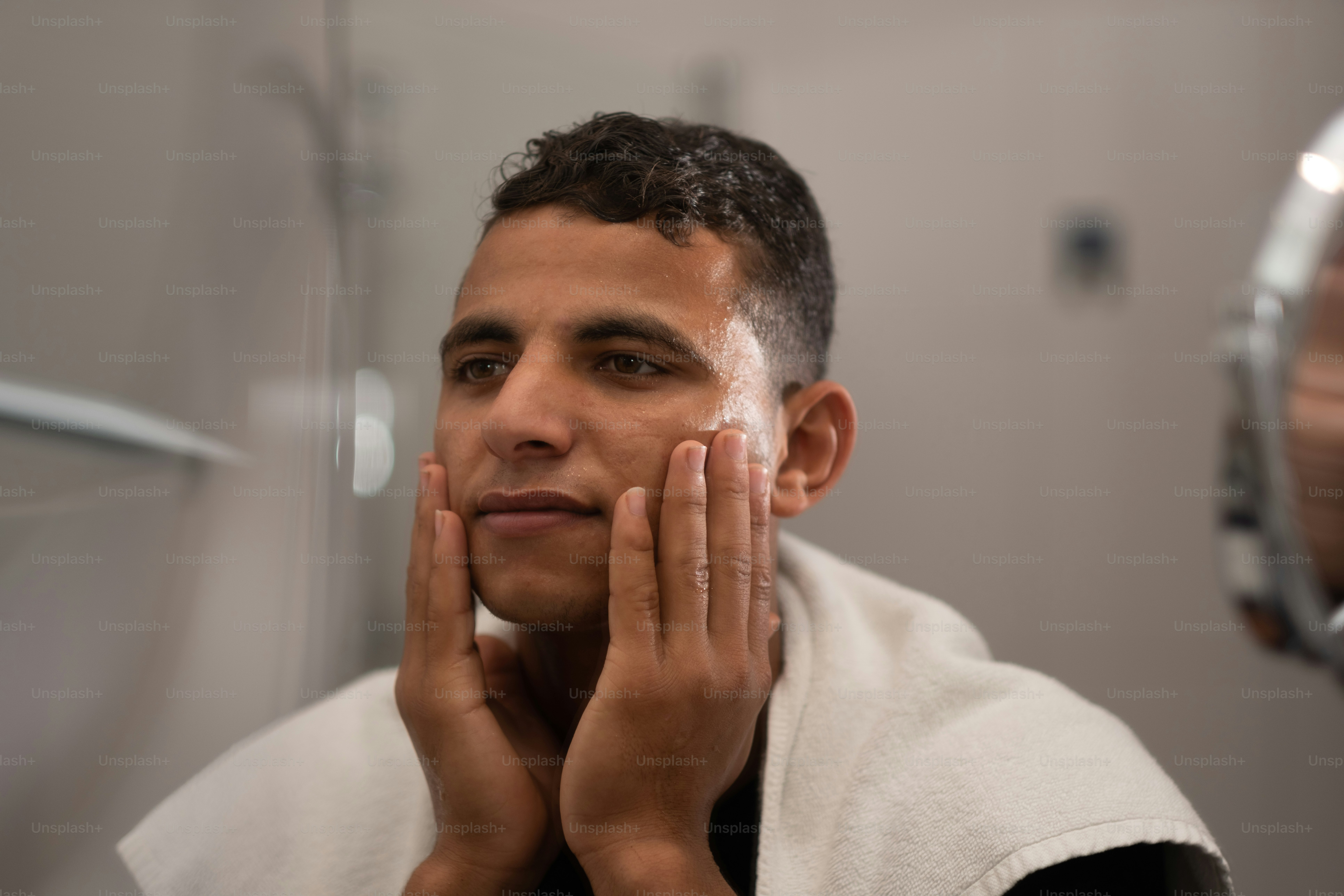 Un homme se rase le visage devant un miroir photo