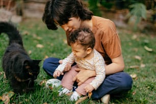 a woman is playing with a baby and a cat