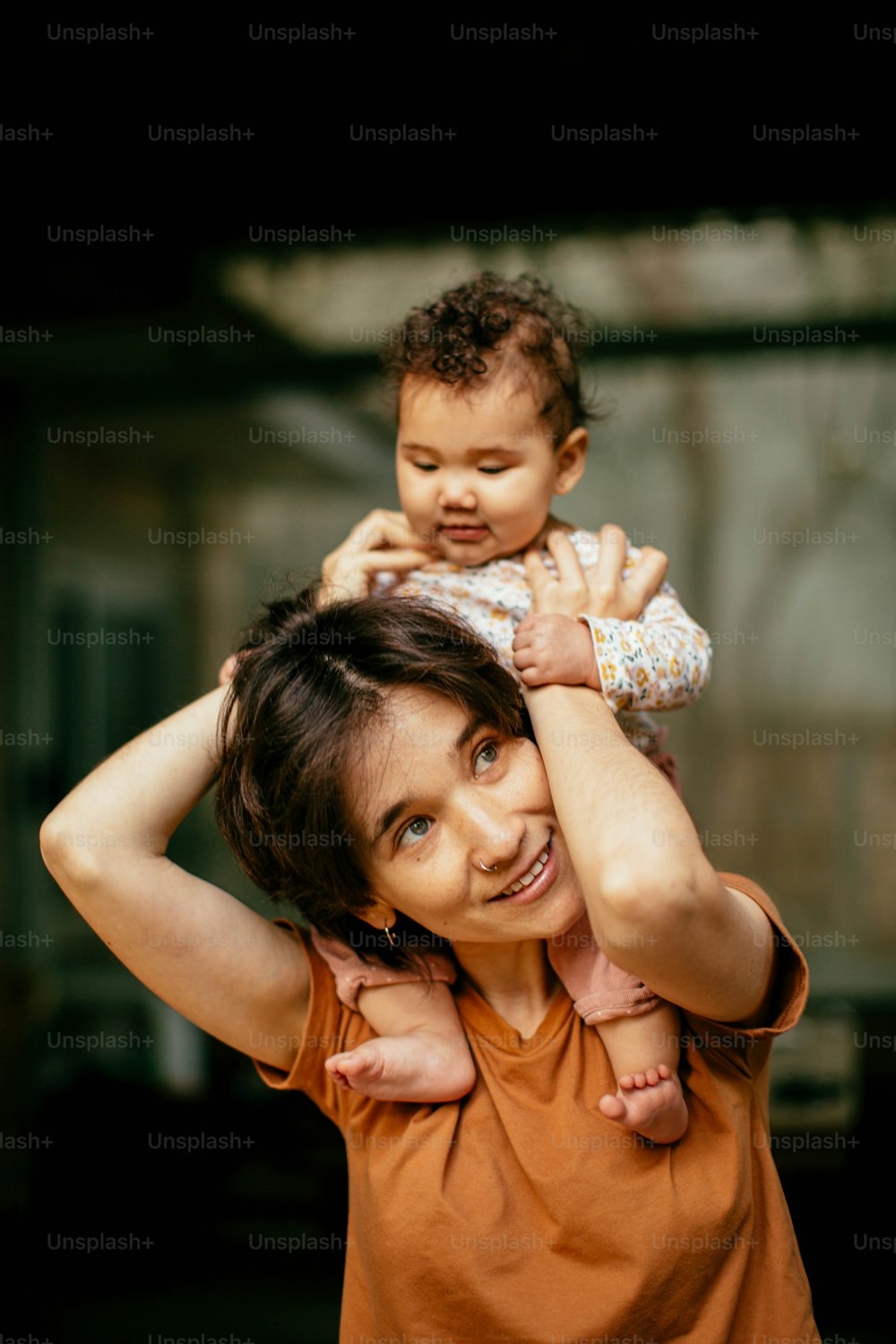a woman holding a baby up to her head