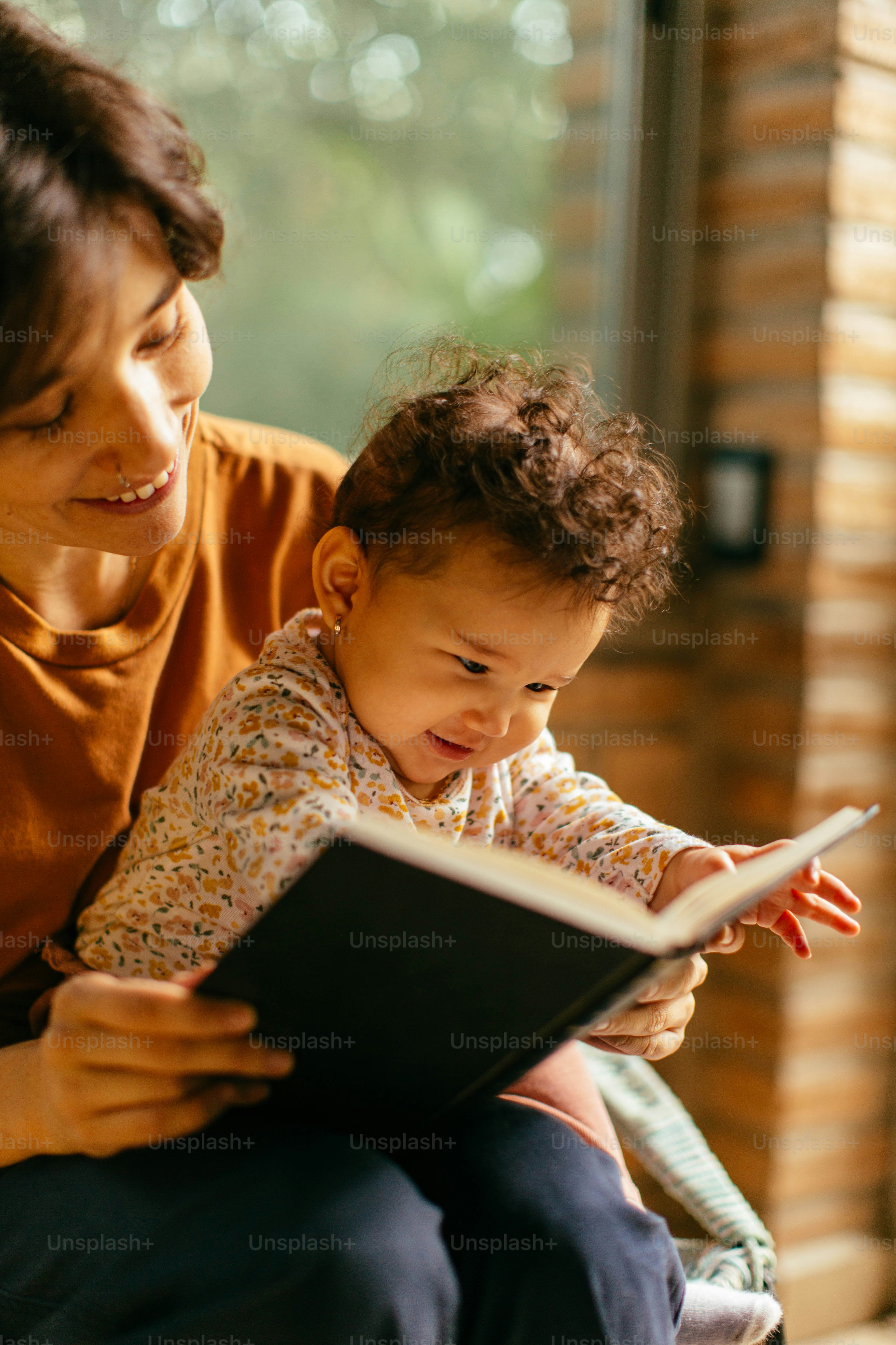 Una mujer leyendo un libro a un bebé foto – Imagen de Familia en Unsplash