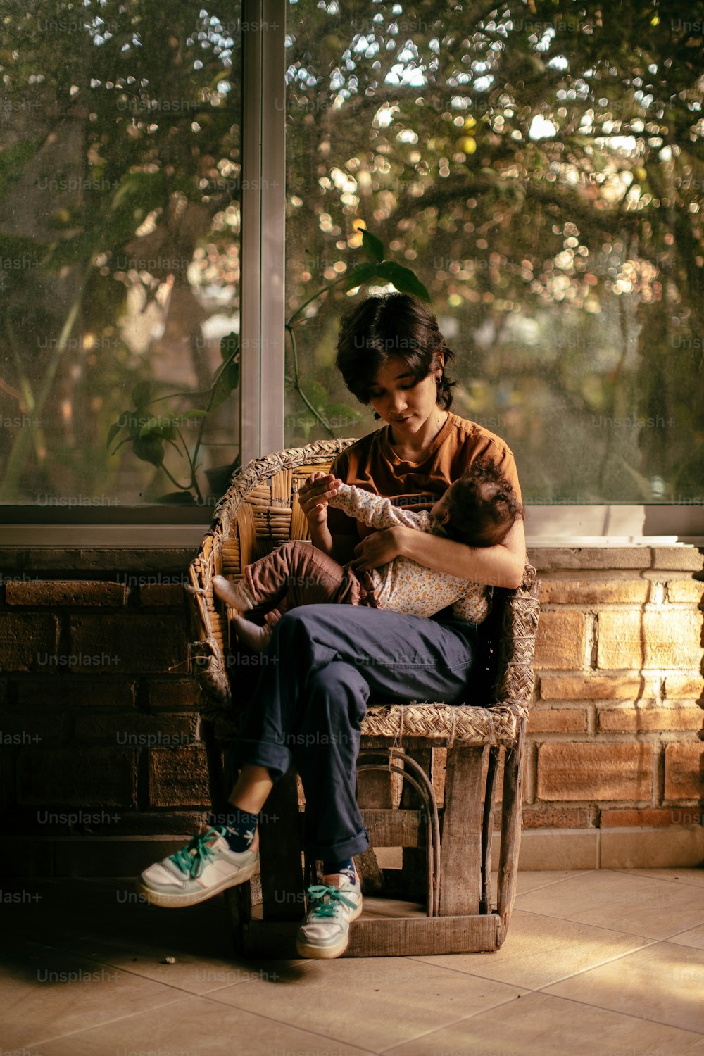 a woman sitting on a chair holding a baby