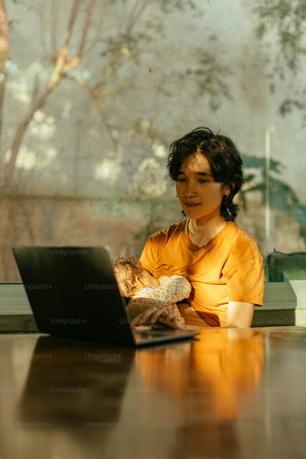 노트북이 있는 테이블에 앉아 있는 여자