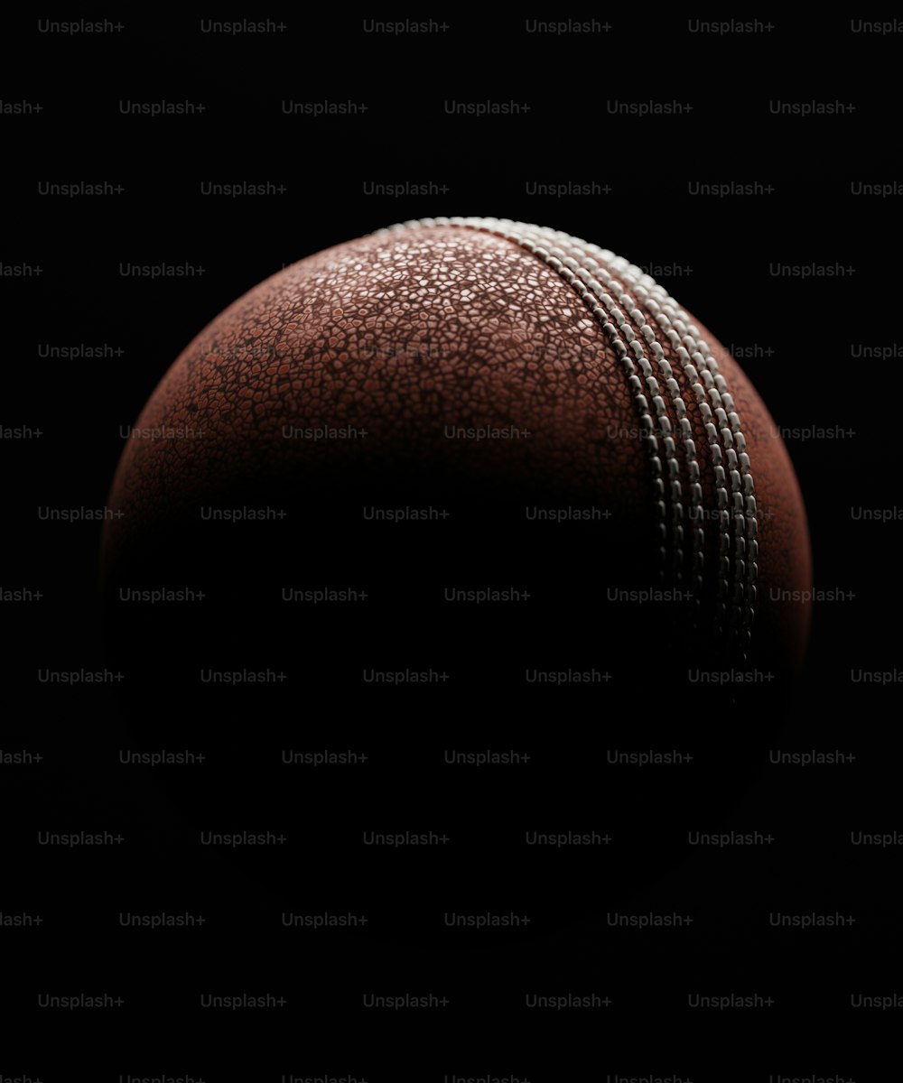 a close up of a cricket ball on a black background