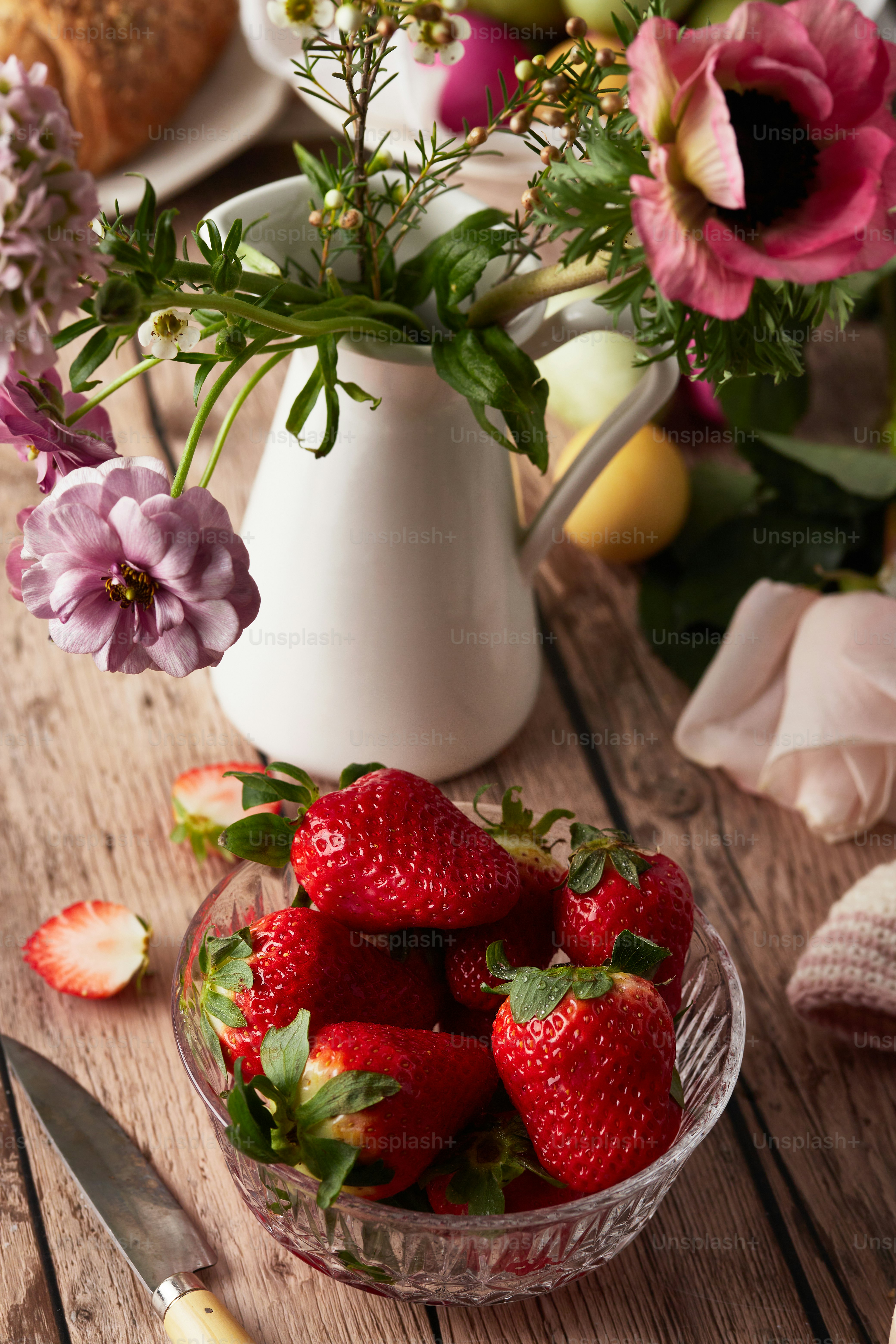a bowl of strawberries on a wooden table