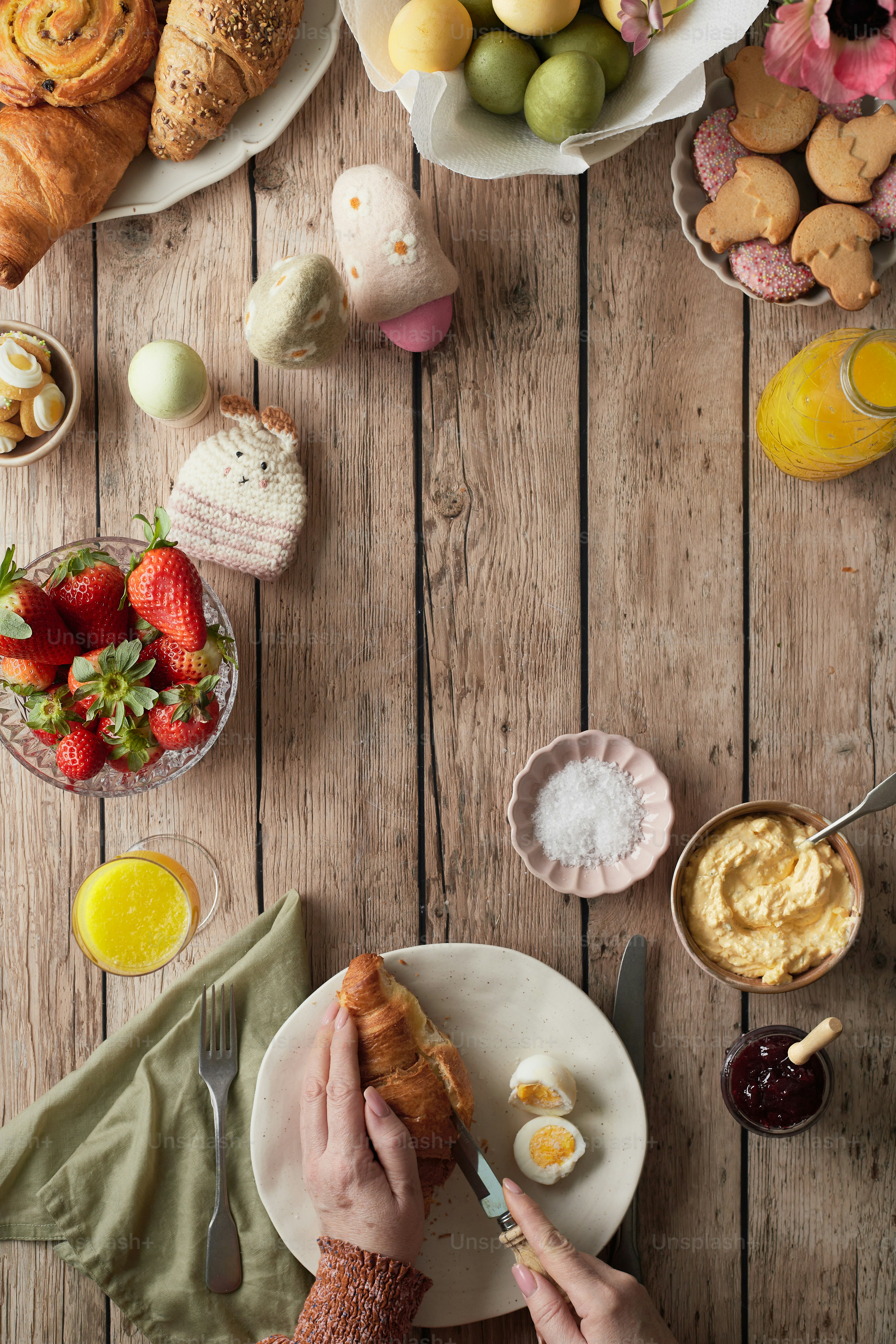 a person eating a croissant on a white plate