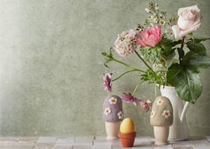 a vase filled with flowers next to two small rocks