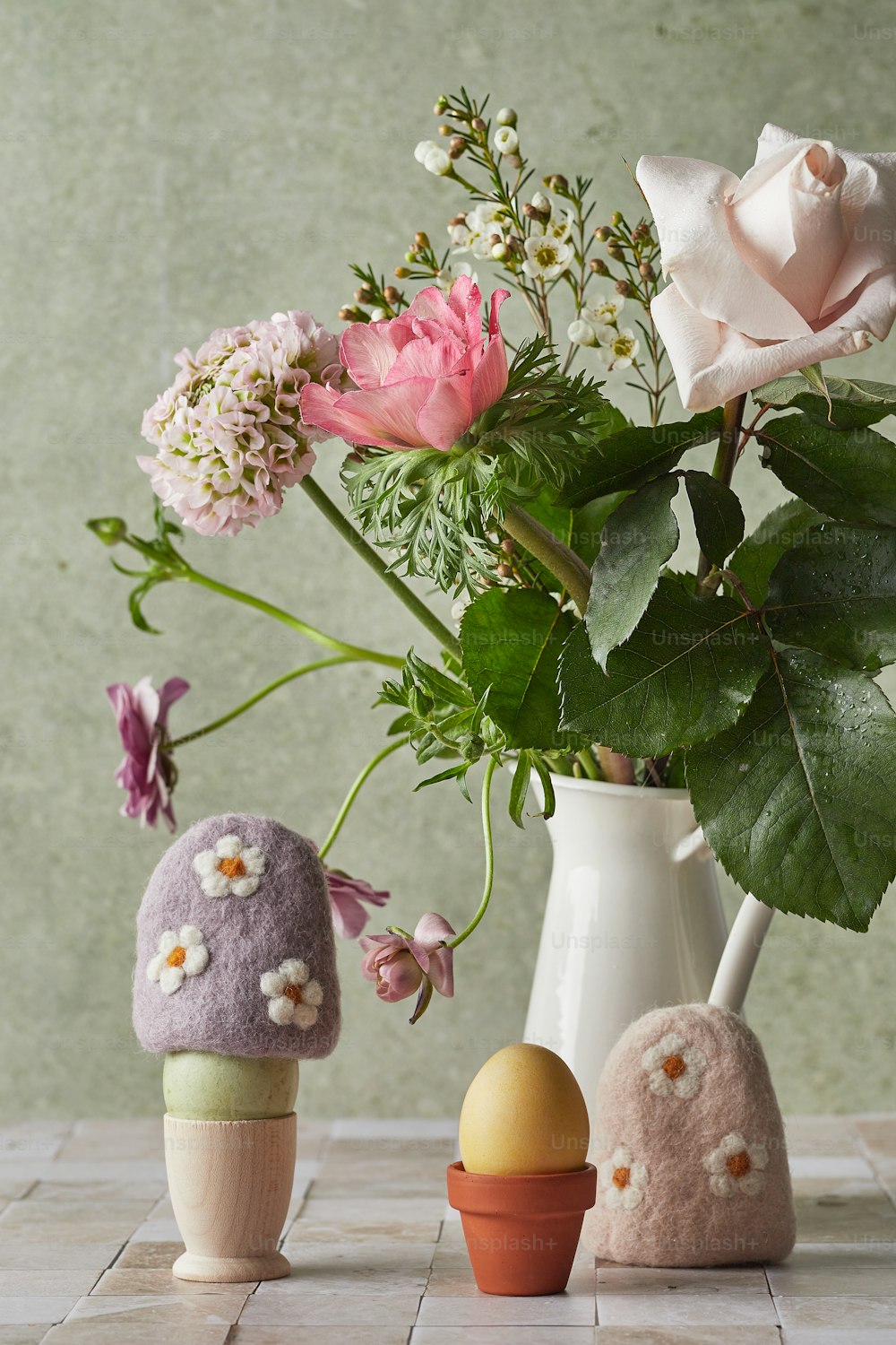 a vase filled with flowers next to two small eggs