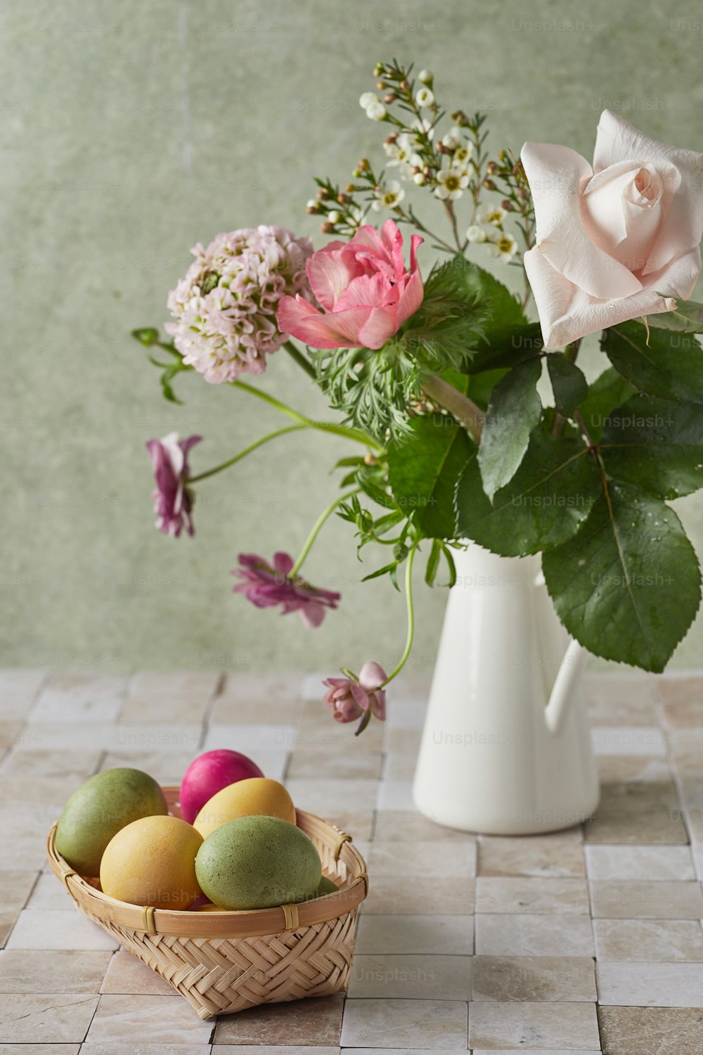 a basket of fruit next to a vase of flowers