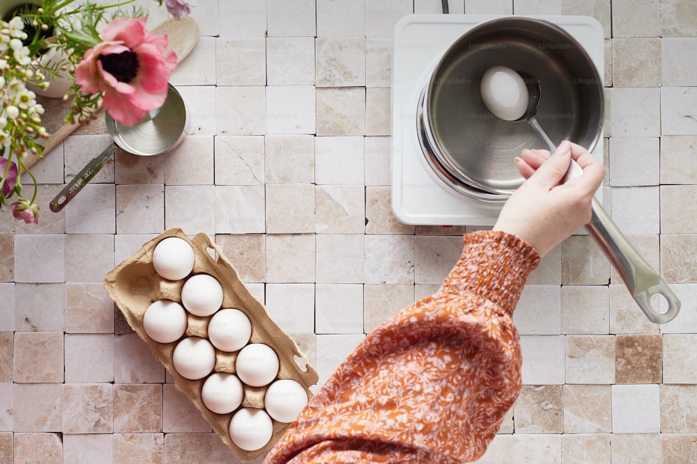 a person reaching for an egg in a carton