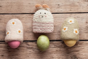 a group of three knitted eggs sitting on top of a wooden table