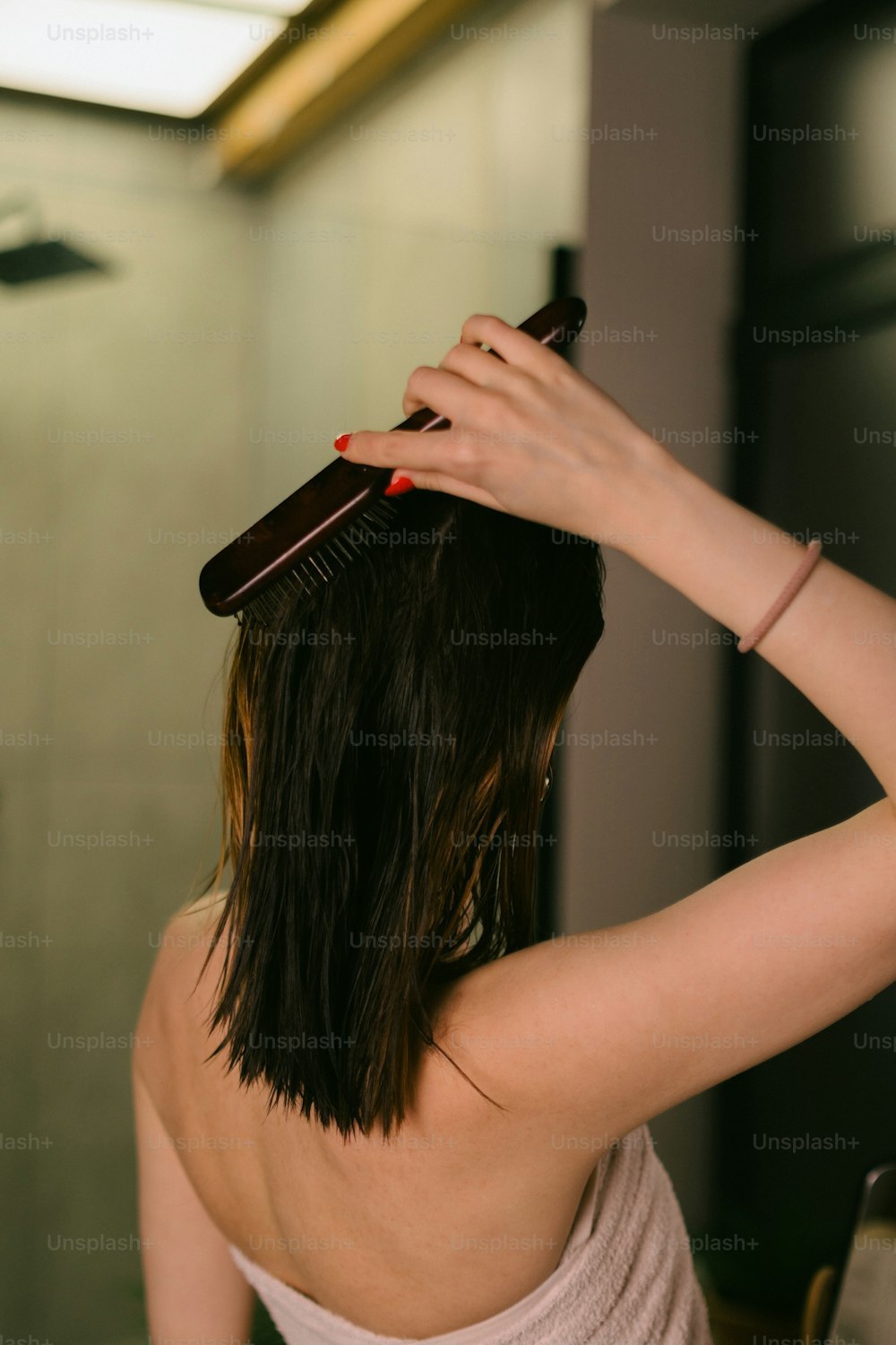 a woman brushing her hair with a hair brush